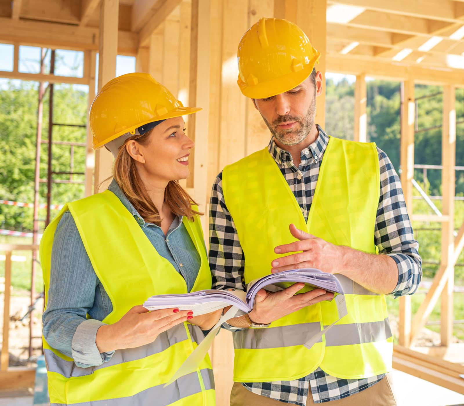 woman and man discussing blueprints in new home under construction